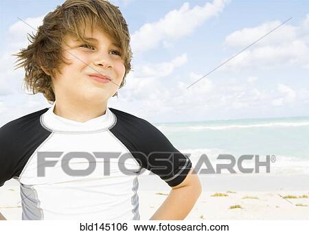 Stock Photograph - Smiling Caucasian boy on beach. Fotosearch