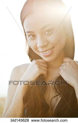 Smiling Chinese woman holding her hair View Large Photo Image Stock Photo - Smiling Chinese woman holding her hair. Fotosearch
