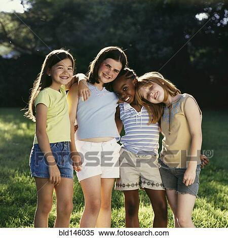 Smiling girls hugging outdoors View Large Photo Image Stock Photography - Smiling girls hugging outdoors. Fotosearch