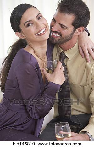 Smiling Hispanic couple drinking wine and hugging View Large Photo Image Stock Image - Smiling Hispanic couple drinking wine and hugging. Fotosearch