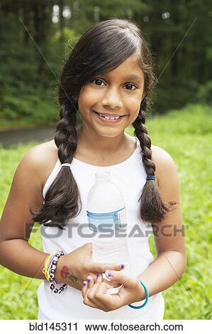 Stock Image - Smiling Hispanic girl holding bottled water. Fotosearch