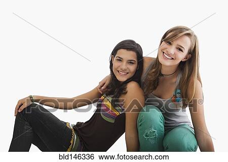 Stock Photograph - Smiling Hispanic sisters hugging. Fotosearch