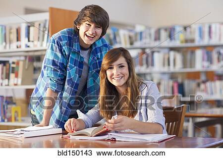 Smiling students doing homework in library View Large Photo Image Stock Image - Smiling students doing homework in library. Fotosearch