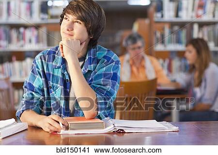 Stock Image - Student daydreaming in library. Fotosearch