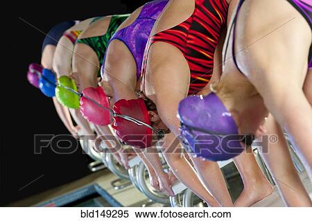 Swimmers preparing to dive off starting blocks View Large Photo Image Stock Photography - Swimmers preparing to dive off starting blocks. Fotosearch
