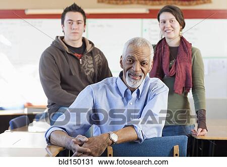 Stock Image - Teacher and students in classroom. Fotosearch