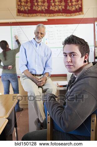 Stock Photo - Teacher and students talking in classroom. Fotosearch