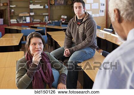 Teacher and students talking in classroom View Large Photo Image Stock Photograph - Teacher and students talking in classroom. Fotosearch