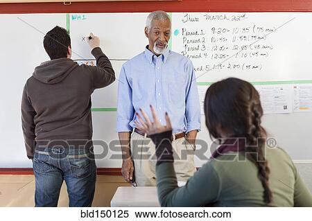 Stock Photography - Teacher and students talking in classroom. Fotosearch