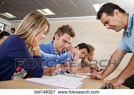 Teacher helping Hispanic college students View Large Photo Image Stock Photo - Teacher helping Hispanic college students. Fotosearch