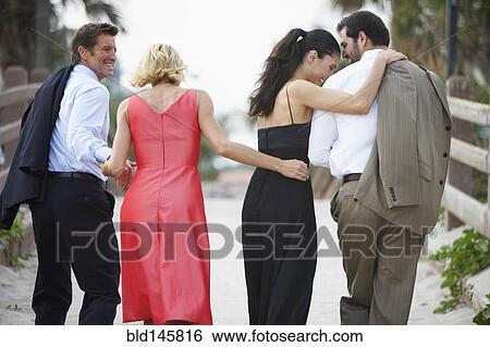 Stock Photograph - Two elegant couples walking down path together. Fotosearch