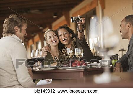 Women taking self-portrait in restaurant View Large Photo Image Stock Image - Women taking self-portrait in restaurant. Fotosearch