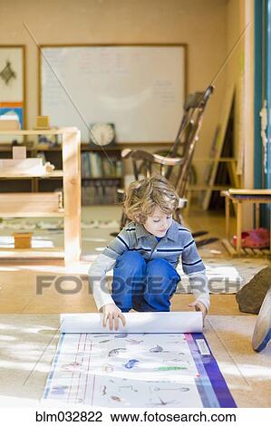 Boy rolling up poster in classroom View Large Photo Image Stock Image - Boy rolling up poster in classroom. Fotosearch
