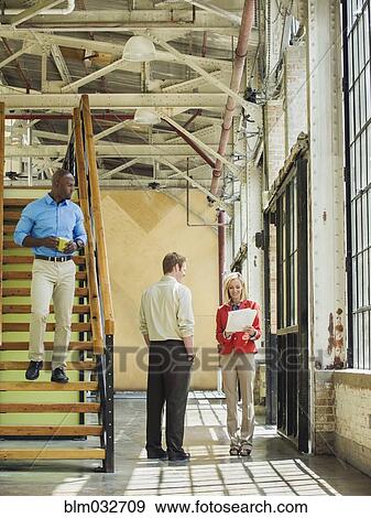 Stock Photo - Business people talking in warehouse. Fotosearch