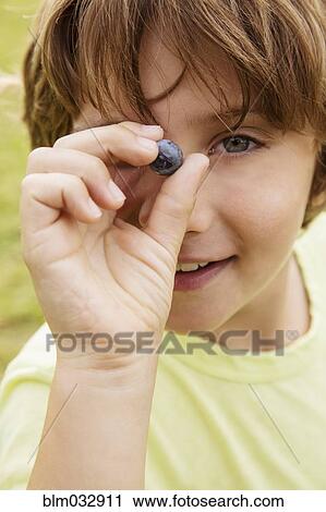 Caucasian boy holding blueberry outdoors View Large Photo Image Stock Image - Caucasian boy holding blueberry outdoors. Fotosearch