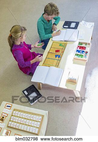 Stock Photo - Caucasian children at table in classroom. Fotosearch