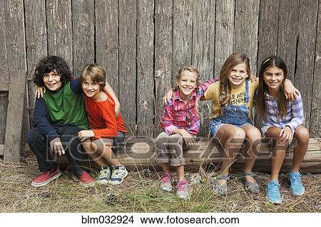 Caucasian children smiling together on wooden log View Large Photo Image Picture - Caucasian children smiling together on wooden log. Fotosearch
