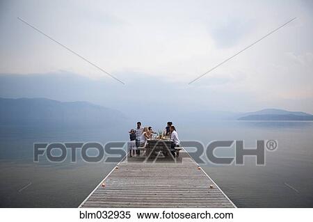 Caucasian family at picnic table on wooden dock over lake View Large Photo Image Stock Photography - Caucasian family at picnic table on wooden dock over lake. Fotosearch