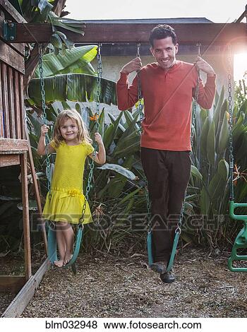 Caucasian father and daughter standing on swings View Large Photo Image Stock Photo - Caucasian father and daughter standing on swings. Fotosearch