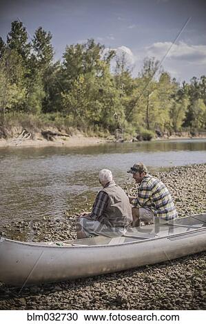 Caucasian father and son sitting in canoe on riverbed View Large Photo Image Stock Image - Caucasian father and son sitting in canoe on riverbed. Fotosearch