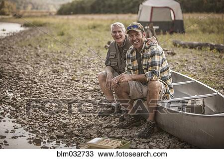 Caucasian father and son sitting in canoe at campsite View Large Photo Image Stock Image - Caucasian father and son sitting in canoe at campsite. Fotosearch