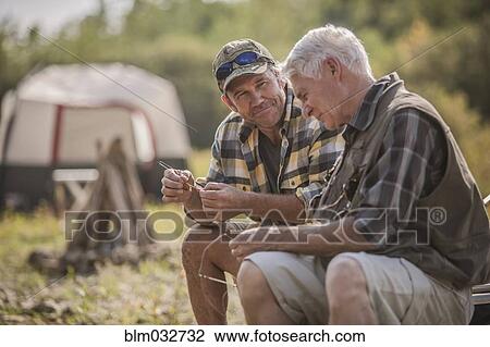 Caucasian father and son tying fishing lures at campsite View Large Photo Image Stock Image - Caucasian father and son tying fishing lures at campsite. Fotosearch