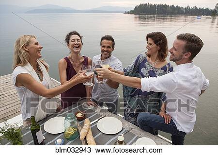 Caucasian friends toasting at outdoor lunch View Large Photo Image Stock Image - Caucasian friends toasting at outdoor lunch. Fotosearch