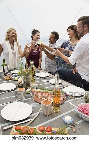 Caucasian friends toasting at outdoor lunch View Large Photo Image Stock Photo - Caucasian friends toasting at outdoor lunch. Fotosearch