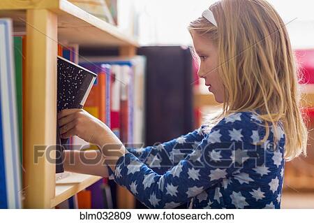 Caucasian girl selecting book in library View Large Photo Image Stock Photo - Caucasian girl selecting book in library. Fotosearch