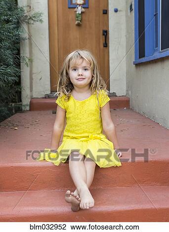 Stock Image - Caucasian girl sitting on front stoop. Fotosearch