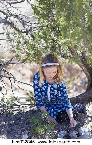 Stock Photograph - Caucasian girl sitting under tree. Fotosearch