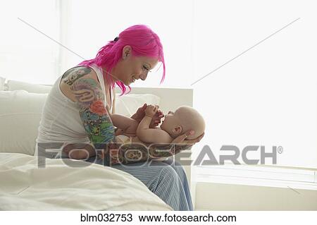 Caucasian mother with pink hair and tattoos cradling baby View Large Photo Image Stock Image - Caucasian mother with pink hair and tattoos cradling baby. Fotosearch