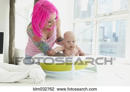 Caucasian mother with pink hair and tattoos bathing baby View Large Photo Image Stock Image - Caucasian mother with pink hair and tattoos bathing baby. Fotosearch