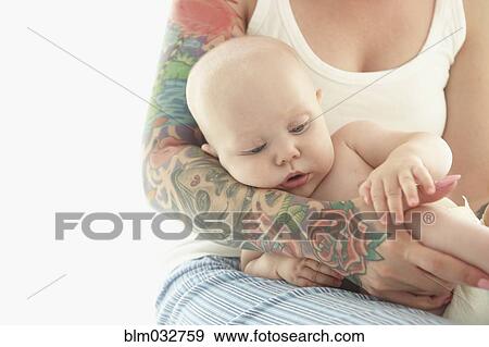 Caucasian mother with tattoos cradling baby View Large Photo Image Stock Photo - Caucasian mother with tattoos cradling baby. Fotosearch