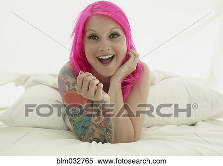 Caucasian woman with pink hair and tattoos laying on bed View Large Photo Image Stock Photography - Caucasian woman with pink hair and tattoos laying on bed. Fotosearch