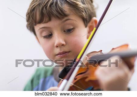 Stock Image - Close up of boy playing violin. Fotosearch