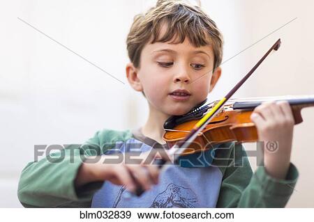 Stock Photo - Close up of boy playing violin. Fotosearch