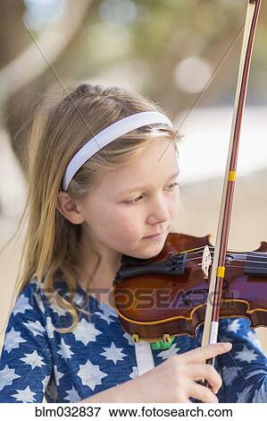 Stock Photo - Close up of Caucasian girl playing violin. Fotosearch
