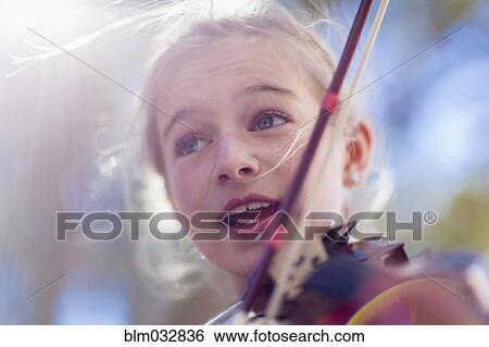 Stock Photograph - Close up of Caucasian girl playing violin. Fotosearch
