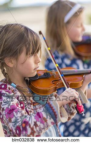 Stock Photo - Close up of girls playing violin. Fotosearch