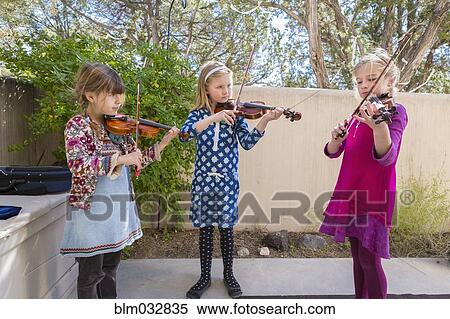 Stock Photography - Girls playing violin outdoors. Fotosearch