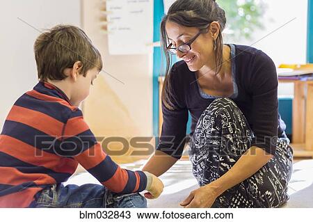 Montessori teacher helping student in classroom View Large Photo Image Stock Image - Montessori teacher helping student in classroom. Fotosearch
