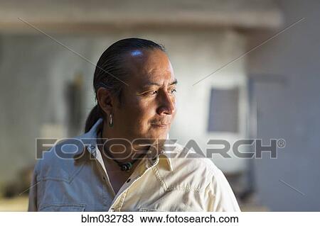 Stock Image - Native American man smiling indoors. Fotosearch
