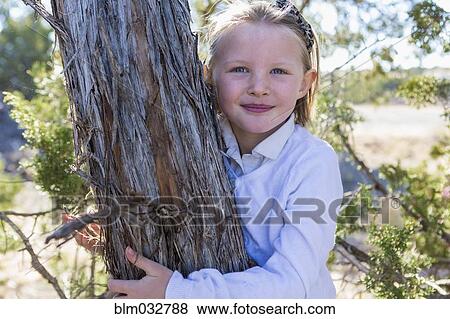 Smiling girl hugging tree View Large Photo Image Stock Photo - Smiling girl hugging tree. Fotosearch