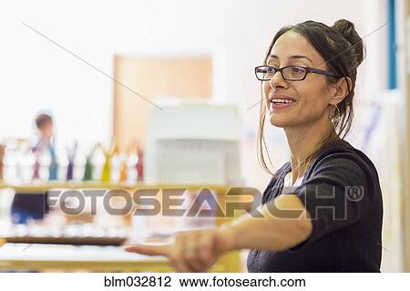 Stock Image - Teacher gesturing in classroom. Fotosearch
