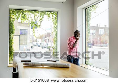 African American businessman talking on cell phone in office View Large Photo Image Stock Photo - African American businessman talking on cell phone in office. Fotosearch