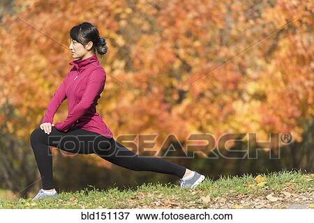 Asian runner stretching in park View Large Photo Image Stock Photo - Asian runner stretching in park. Fotosearch