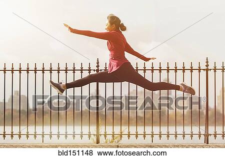 Asian woman leaping on waterfront path View Large Photo Image Stock Photo - Asian woman leaping on waterfront path. Fotosearch