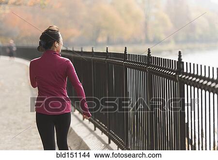 Asian woman running on waterfront path View Large Photo Image Picture - Asian woman running on waterfront path. Fotosearch