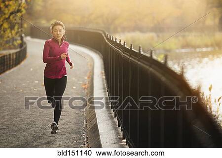 Asian woman running on waterfront path View Large Photo Image Stock Image - Asian woman running on waterfront path. Fotosearch